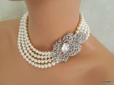 "This glamorous necklace has an art deco brooch with clear rhinestones and strung with Austrian pearls in cream. Brooch has clear rhinestones and measures 2.75 by 2\" wide. This beautiful brooch is enhanced with an Austrian oval crystal in the middle for extra sparkle. Necklace is strung with pearls that measure 8 mm. Inner strand measures approximately 17\". Finished off with a filigree attached to a lobster claw closure and 2\" extender chain for additional length. Please choose desired pearl Wedding Necklace Pearl, Art Deco Brooch, Bridal Pearl Necklace, Pearl Bridal Jewelry, Pearl Necklace Wedding, Sparkle Necklace, Necklace Wedding, Rhinestone Wedding, Necklace Pearl