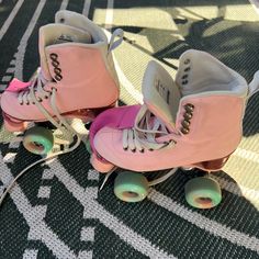 two pink roller skates sitting on top of a rug