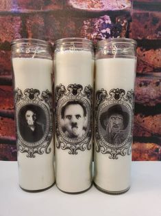 three candles with pictures on them sitting next to each other