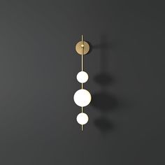 two lights are hanging on the wall in front of a black background with white circles