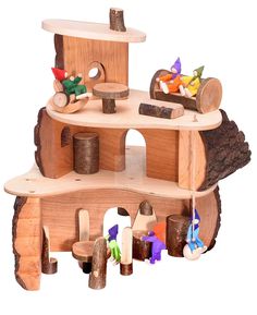 a wooden toy house made out of wood with toys on the top and around it