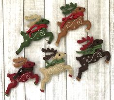 five handmade christmas ornaments hanging on a white wooden wall with snowflakes and reindeers