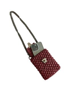 a red cell phone case with a camera attached to the strap that is connected to it