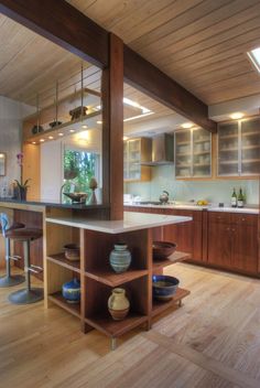 an open kitchen with wooden floors and cabinets in the center is surrounded by wood flooring