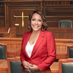 a woman in a red suit standing in front of a courtroom