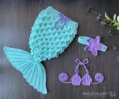 two crocheted items are laying next to each other on a table with flowers