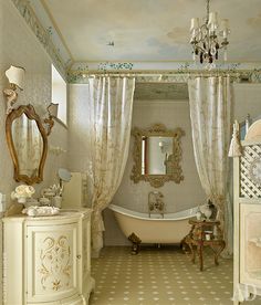 a fancy bathroom with an antique tub, chandelier and mirror on the wall