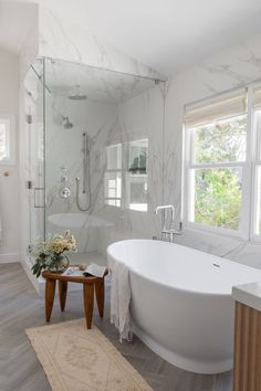 a large white bath tub sitting next to a walk in shower