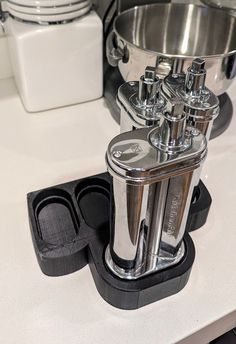 a kitchen counter with several pots and pans on top of it, including one being used as an appliance