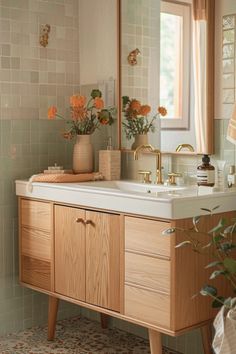 a bathroom with a sink, mirror and flowers in vases on the counter top