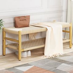 a wooden bench sitting next to a plant on top of a hard wood floor in front of a white wall