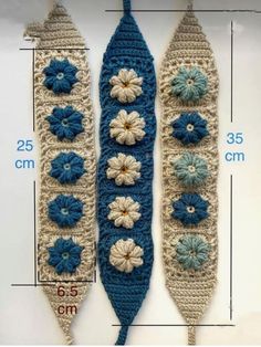 two crocheted blue and white flowers are next to each other on a ruler