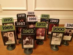 a table topped with pictures and plaques on top of a wooden floor next to a wall