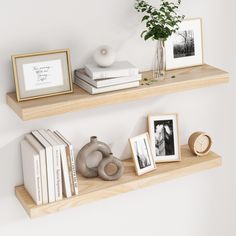 two wooden shelves with books and pictures on them next to a vase filled with flowers