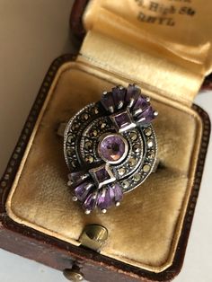 Beautiful bezel ring, in sterling silver and natural amethyst gems, with added Marcassite elements. A beautiful geometric design typical of Art Deco, the stones are cut very well and have different shapes and a beautiful light and reflections, very elegant and feminine. Excellent vintage condition, all stones are present and firmly anchored to the bezel, light signs of wear and patina of age, requires cleaning if desired. The box is not included Size IT 14, US 6.5, UK N, FR 54 1940s Italy, Antique Amethyst Ring, Bezel Ring, Amethyst Gem, Lighted Signs, Amethyst Ring, Beautiful Lights, Ring Sterling Silver, Different Shapes