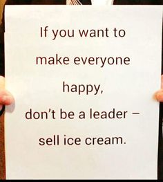 a man holding up a sign that says if you want to make everyone happy, don't be a leader - sell ice cream