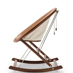 a wooden rocking chair with a white and brown blanket on it's backrest