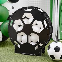 a soccer ball sitting on top of a field next to balloons and streamers in the background