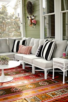 a white couch sitting on top of a wooden floor next to a table and chairs