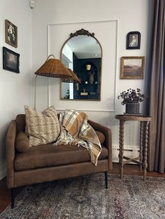 a living room with a couch, mirror and lamp on the side table in front of it