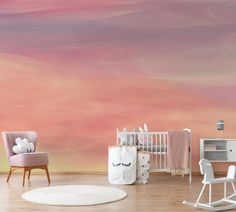 a baby's room with pink and orange clouds painted on the wall behind it