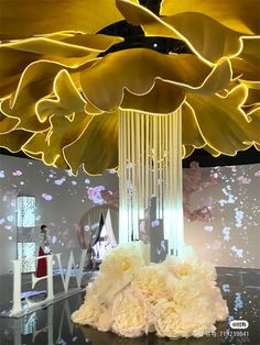 a chandelier hanging from the ceiling in a room with white flowers on it