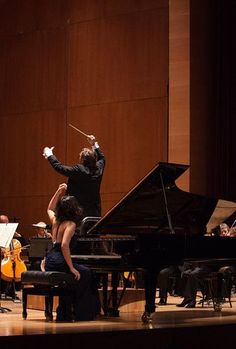 conductor and orchestra performing on stage with instruments