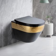 a black and gold toilet sitting on top of a white counter next to a wall