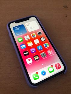 an iphone on a wooden table with icons displayed in the screen and back side view