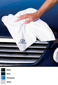 a person wiping up the hood of a car with a microfibrel cloth