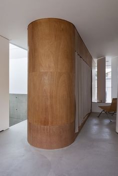 a large wooden object in the middle of a room with white walls and flooring