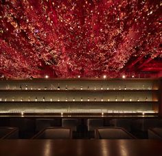 the ceiling is covered with red flowers and lights