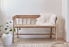 a wooden bench sitting on top of a white rug