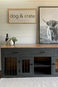 a dog and crate display in a living room with a cow print on the wall