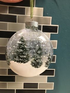 a christmas ornament hanging from the side of a wall with snow on it