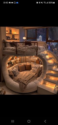 a circular bed in the middle of a room with stairs leading up to it and lights on either side