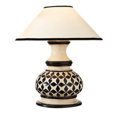 a table lamp with a white shade on it's top and black trim around the base