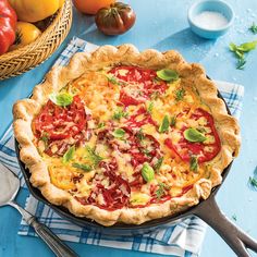 a pizza sitting on top of a blue table next to other food and utensils