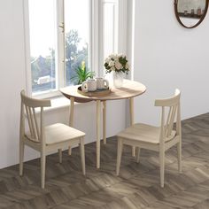 a table and two chairs in front of a window with a potted plant on it