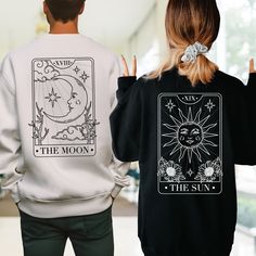 "Enhance your connection with our Couples Matching Sweatshirt, each adorned with iconic Tarot cards - \"The Sun\" and \"The Moon.\" These shirts symbolize the harmonious balance of light and shadow within your relationship. Crafted from premium materials, they offer unparalleled comfort and quality. Perfect for anniversaries, engagements, or simply celebrating your unique bond. Embrace the magic of love and cosmic unity with these captivating designs. 💙How To Order?🧡 𝟏. Choose your shirt Size, 𝟐. Choose your shirt Color, 𝟑. Select the quantity, 𝟒. Click Add To Court. For multiple items go back to the listing and repeat the steps. If you have any difficulties, send us a message or click on the \"Request A Custom Order\" button and we'll create a private listing for you. 💙 Custom Desi Cute Matching Shirts For Couples, Couple Shirt Design Ideas Aesthetic, Couples Shirts Matching, Matching Tshirt Couple, Themed Long Sleeve Fan Merchandise Tops, Couple Sweatshirts Aesthetic, Themed Long Sleeve Tops With Graphic Print, Themed Long Sleeve Tops With Letter Print, Themed Long Sleeve T-shirt With Letter Print