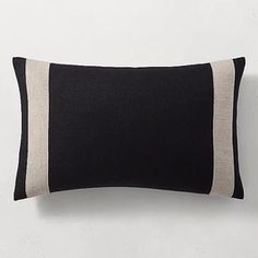 a black and white pillow sitting on top of a bed