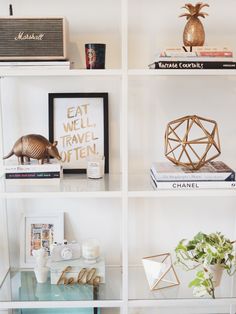 an image of a shelf with books and other items on it, including vases