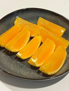 sliced up oranges on a black plate