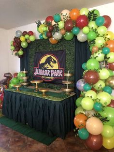 a table topped with balloons and decorations next to a sign that reads jumble park