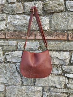 Cognac leather crossbody bag, This bag is a medium size classic crossbody bag. This bag is unlined.  The bag is closed by a magnetic button. This bag you can take every where in any occasion Features : - Cognac leather, - Brass finishing, - Unlined. Size :  - Width 10.2 inch, - Height 8.2 inch, - Adjustable shoulder belt length max 45 inch. If you want to add a boho touch to your bag, buy a suede tassel separately use this link  https://www.etsy.com/it/listing/1524528378/nappina-portachiavi-in-pelle-scamosciata?click_key=7fb2fd2620a322dc68df4e06dd903348ab88127c%3A1524528378&click_sum=bae350f5&ref=hp_opfy-4&frs=1 Contact me for any information                --------------------------------------- The shipping is made after 10 days by the purchase with express courier.                 ----- Everyday Saddle Flap Bag With Adjustable Strap, Everyday Soft Leather Saddle Bag, Everyday Use Saddle Flap Bag With Adjustable Strap, Daily Use Saddle Bag With Adjustable Strap, Everyday Saddle Satchel With Removable Pouch, Saddle Bag With Removable Pouch, Everyday Saddle Shoulder Bag With Removable Pouch, Classic Crossbody Hobo Bag With Leather Lining, Textured Leather Satchel Flap Bag For Everyday Use