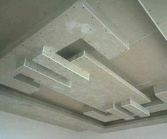 an unfinished ceiling with square and rectangle shapes on the top, suspended from concrete beams