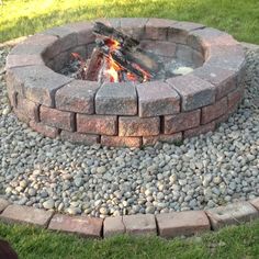 a fire pit sitting on top of a lush green field