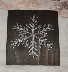 a snowflake made out of wood sitting on top of a wooden tablecloth