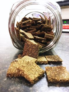 a glass jar filled with dog treats on top of a table