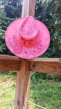 🔴 Note: Please pay attention to the size of the hat before  This is a stiff wide brim western hat in a super cute pink color. The Flowers and Bow are on the the top of the brim/crown and the floral vines are on the bottom of the brim. All hats are burned by hand by me and each design is unique. If you have any questions or want a custom hat feel free to reach out :) - Brim is 3 inches. - This hat is size Medium. It has an elastic band inside that fits 55cm-59cm head Circumference.  -The hat is made of Vegan Suede. -hats should NOT be dry cleaned or washed! -color may vary slightly due to photo lighting and monitor screen differences. Pink Wide Brim Hat For Rodeo, Country Style Flat Crown Hat For Kentucky Derby, Country Style Fedora For Kentucky Derby With Flat Crown, Pink Flat Brim Hat For Country Events, Western Pink Sun Hat With Curved Brim, Pink Western Sun Hat With Curved Brim, Pink Curved Brim Western Sun Hat, Pink Western Wide Brim Straw Hat, Pink Wide Brim Western Straw Hat